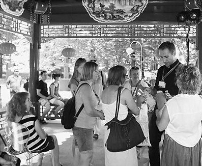 當(dāng)?shù)貙?dǎo)游正在向游客展示中國亭榭的建筑材料模型。