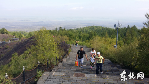 游客登上植被茂密的老黑山。
