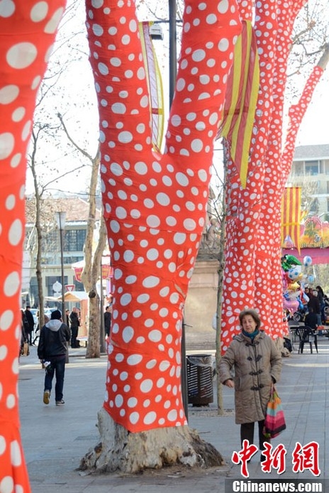 藝術家扮靚冬日街頭 為樹木穿上橙色圓點外衣