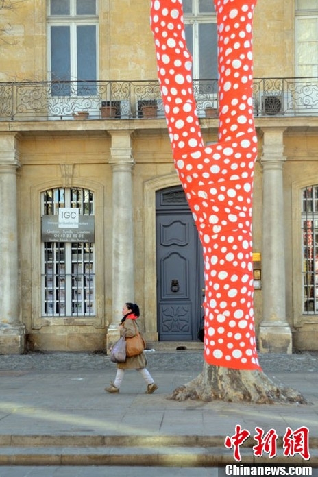 藝術家扮靚冬日街頭 為樹木穿上橙色圓點外衣